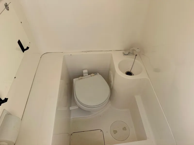 Slide: The Image of 2008 Fountain Center Console boat bathroom with toilet and sink. - 13