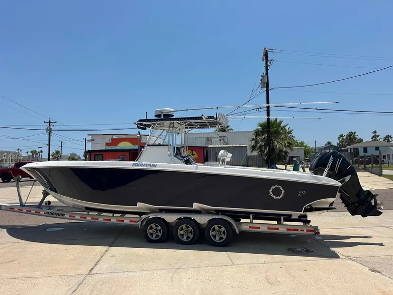 Slide: The Image of 2008 Fountain Center Console boat on a trailer, parked outdoors under clear blue sky. - 4
