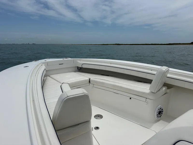 Slide: The Image of 2016 Regulator Center Console boat with white seating, on calm ocean waters. - 13
