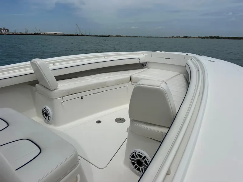 Slide: The Image of 2016 Regulator center console boat with white seating and ocean backdrop. - 14