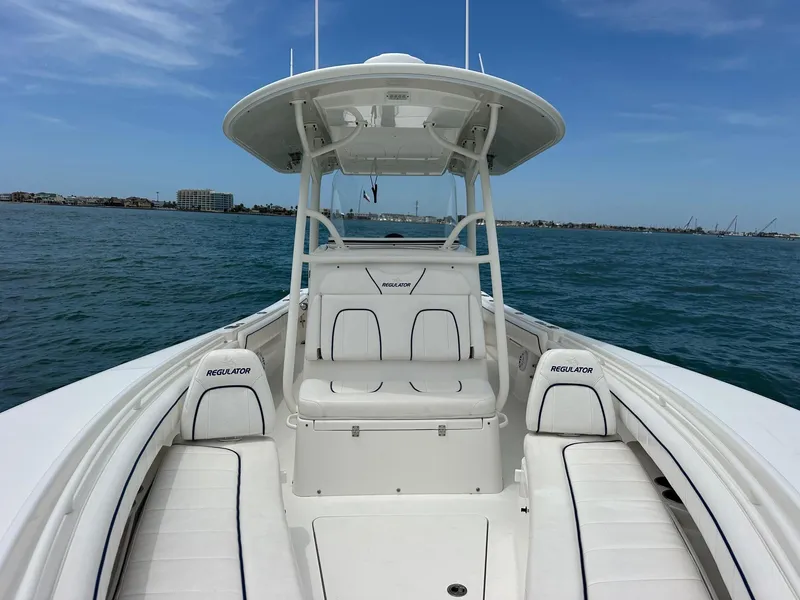 Slide: The Image of 2016 Regulator center console boat on open water, clear sky, coastal background. - 15