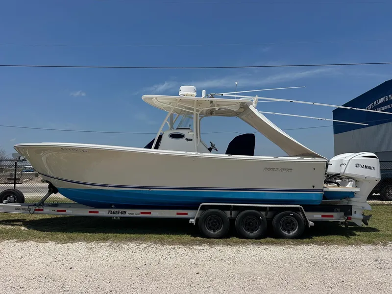 Slide: The Image of 2016 Regulator center console boat on trailer with Yamaha engine, parked outdoors. - 4