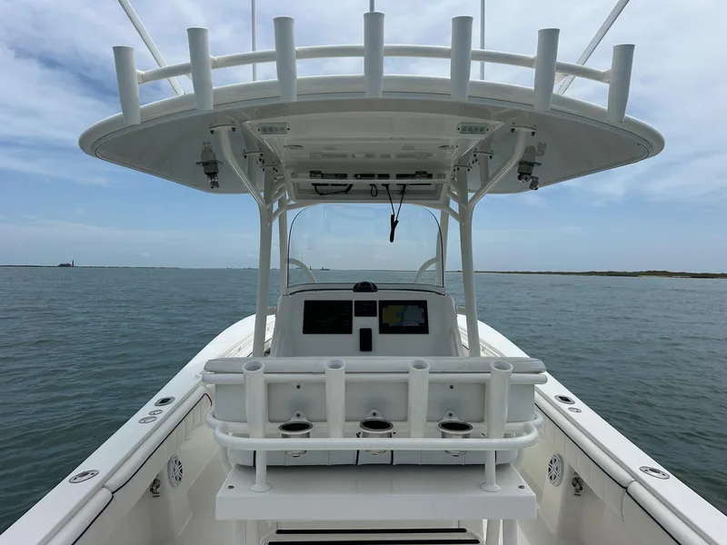 Slide: The Image of 2016 Regulator center console boat on open water, featuring a spacious helm and rod holders. - 9