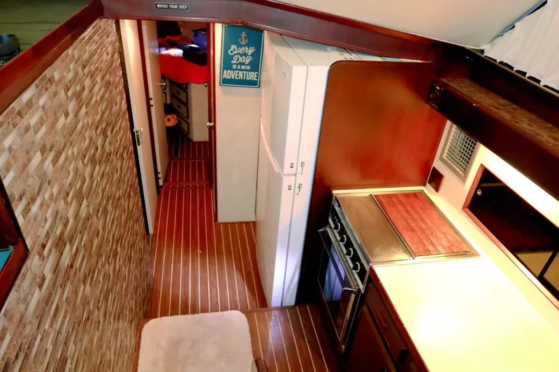 Slide: The Image of Interior of 1983 Bertram 46 Convertible yacht with wood paneling and compact kitchen. - 15