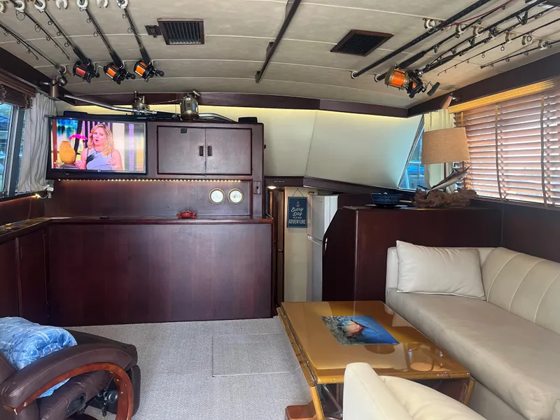 Slide: The Image of Interior of a 1983 Bertram 46 Convertible yacht with cozy seating and fishing rods. - 16