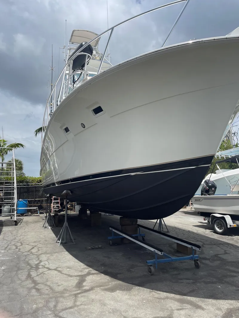 Slide: The Image of 1983 Bertram 46 Convertible yacht on dry dock, showcasing its sleek design and sturdy build. - 21