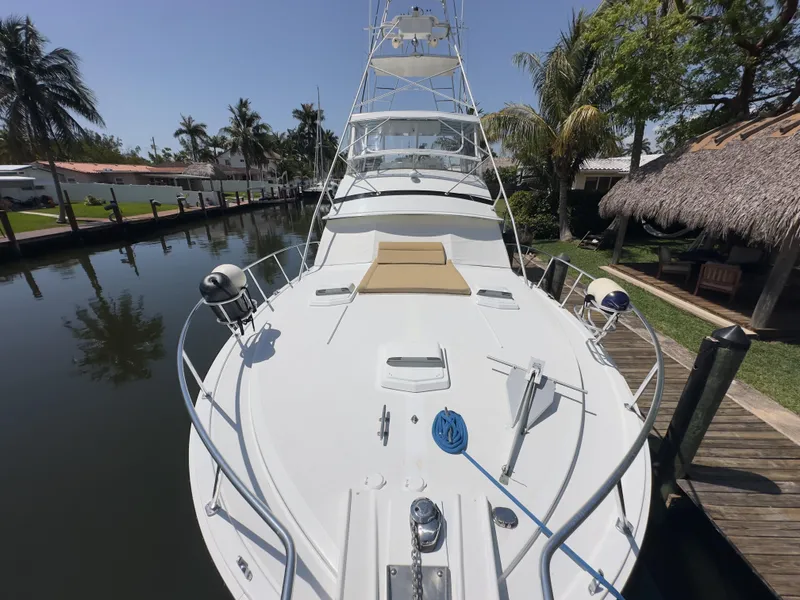 Slide: The Image of 1983 Bertram 46 Convertible yacht docked in a serene marina setting. - 4