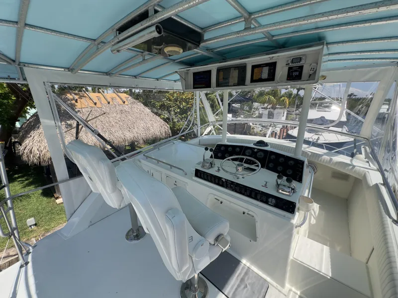 Slide: The Image of 1983 Bertram 46 Convertible yacht helm with dual white captain chairs and navigation instruments. - 8
