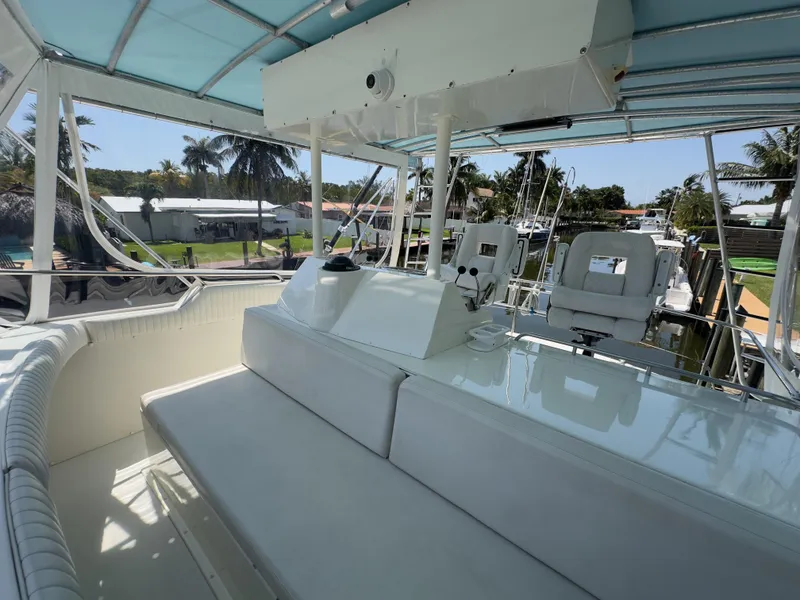 Slide: The Image of 1983 Bertram 46 Convertible yacht interior with seating and helm, under a blue canopy. - 9