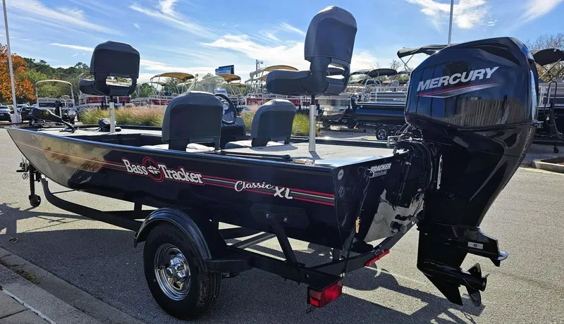Slide: The Image of 2025 Tracker Bass Tracker Classic XL boat with Mercury engine, parked outdoors. - 5