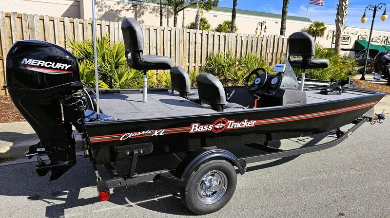 Slide: The Image of 2025 Tracker Bass Tracker Classic XL boat with Mercury engine, parked outdoors. - 6