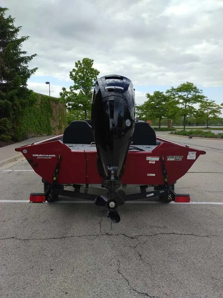 Slide: The Image of 2025 Tracker Pro Team 175 boat with outboard motor in parking lot. - 3