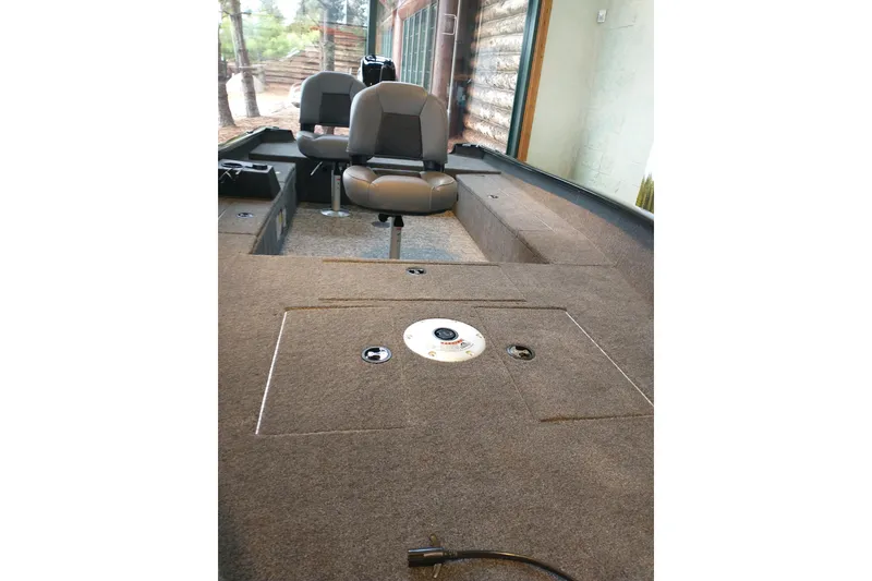 Slide: The Image of Interior of 2025 Tracker Super Guide V-16 T boat with seating and carpeted deck. - 9