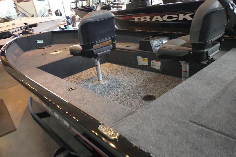 Slide: The Image of 2025 Tracker Super Guide V-16 T boat interior with seating and carpeted deck. - 15
