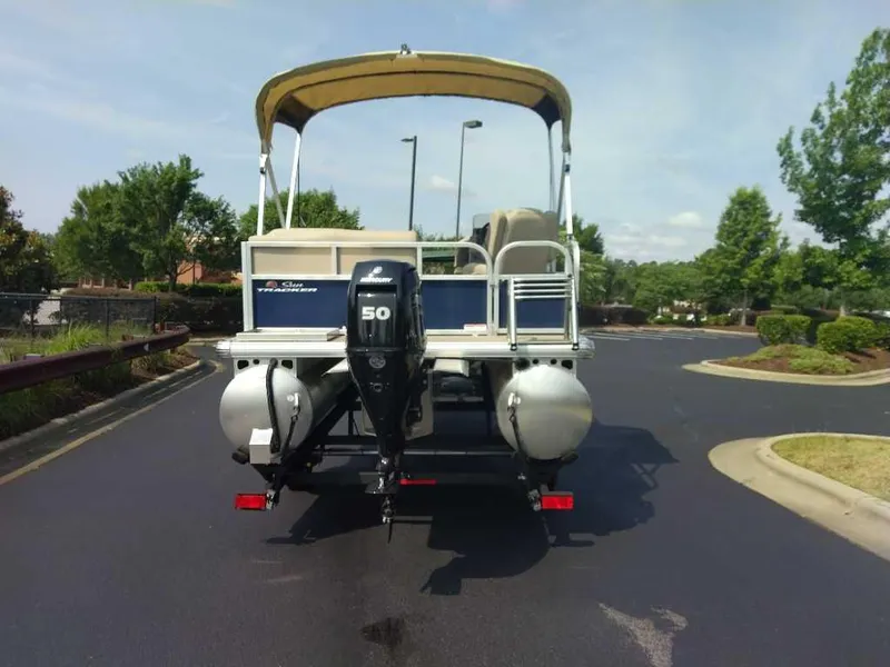 Slide: The Image of 2025 Sun Tracker Bass Buggy 16 XL Select pontoon boat with Mercury 50 engine, parked outdoors. - 4