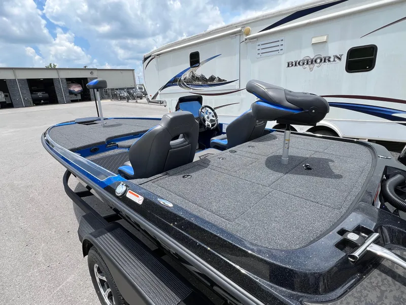 Slide: The Image of 2025 Nitro Z20 XL boat with seating, parked near a Bighorn RV under a cloudy sky. - 4