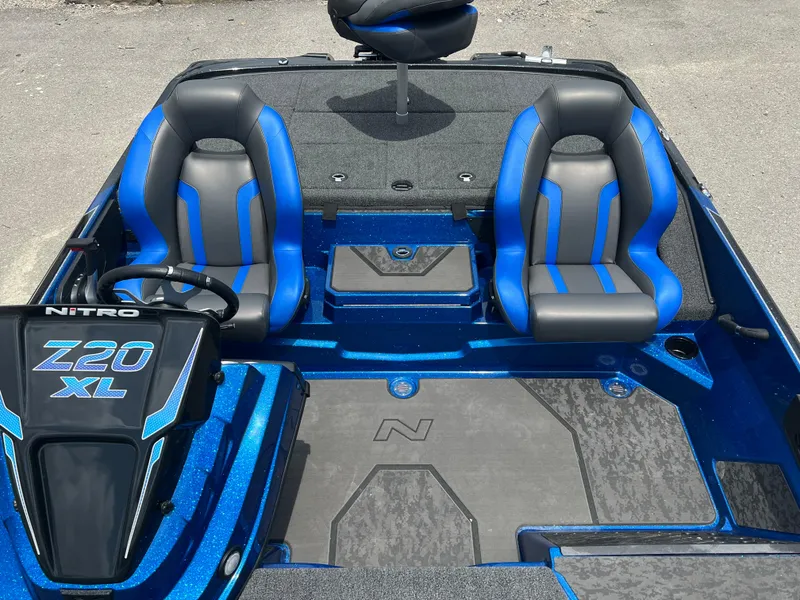 Slide: The Image of 2025 Nitro Z20 XL boat interior with blue and gray seats, steering wheel, and deck. - 7
