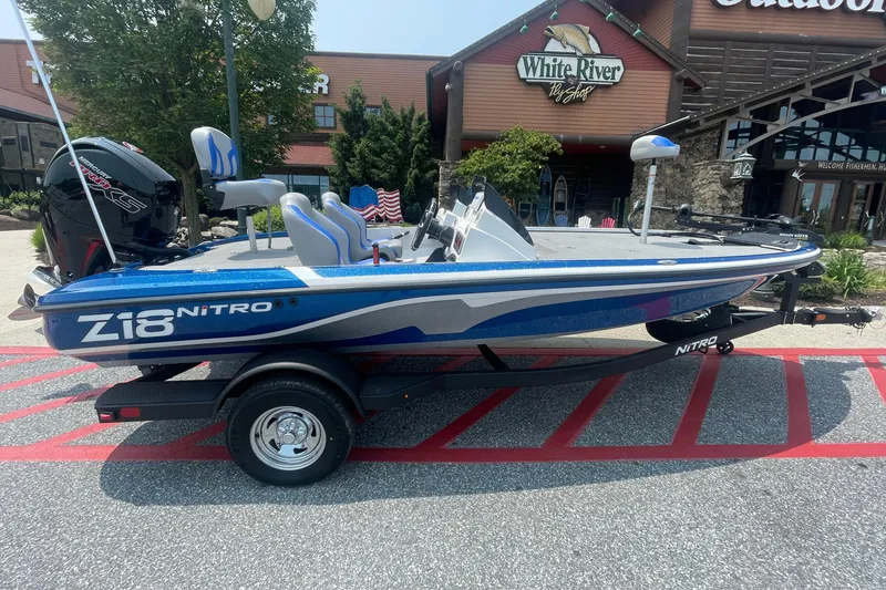 The Image of 2025 Nitro Z18 boat in blue, parked outside a store, showcasing sleek design and modern features. - 0