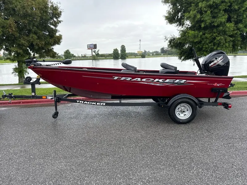The Image of 2025 Tracker Super Guide V-16 T boat on trailer by a lake. - 0