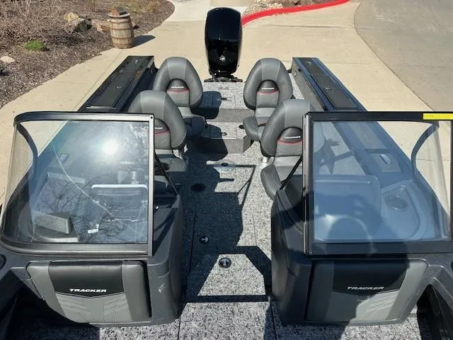 Slide: The Image of 2025 Tracker Targa V-18 WT boat interior with seating and windshield, parked on pavement. - 9
