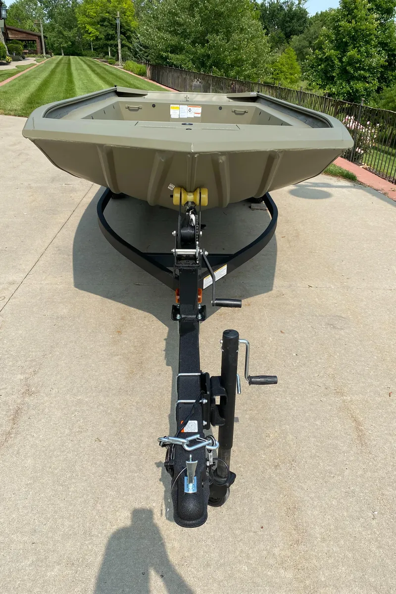 Slide: The Image of 2025 Tracker Grizzly 1754 Jon boat on trailer, parked on concrete driveway. - 2