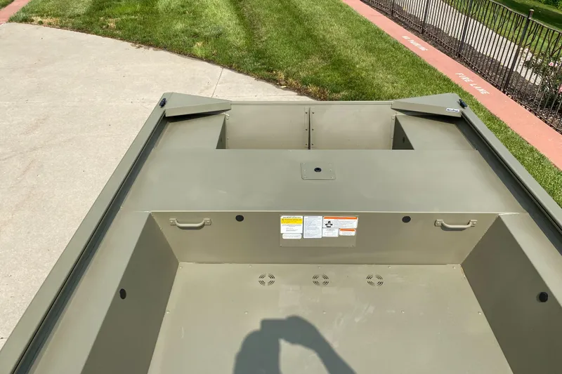 Slide: The Image of 2025 Tracker Grizzly 1754 Jon boat on concrete near grass. - 4