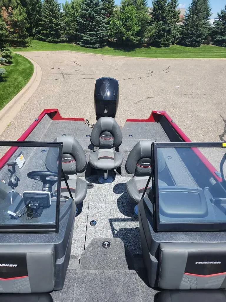 Slide: The Image of 2025 Tracker Pro Guide V-175 Combo boat with seating and windshield, parked on a paved area. - 4