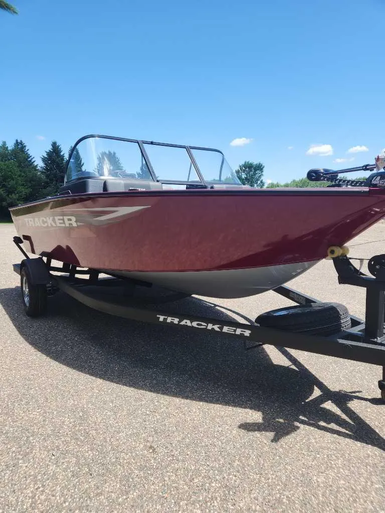 Slide: The Image of 2025 Tracker Pro Guide V-175 Combo boat on trailer, parked outdoors under clear blue sky. - 8