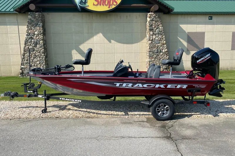 The Image of 2025 Tracker Pro Team 175 boat with Mercury engine, parked on a trailer outside a building. - 0