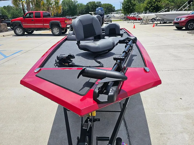 Slide: The Image of 2025 Tracker Pro 170 boat with red exterior and gray seating, parked outdoors. - 4