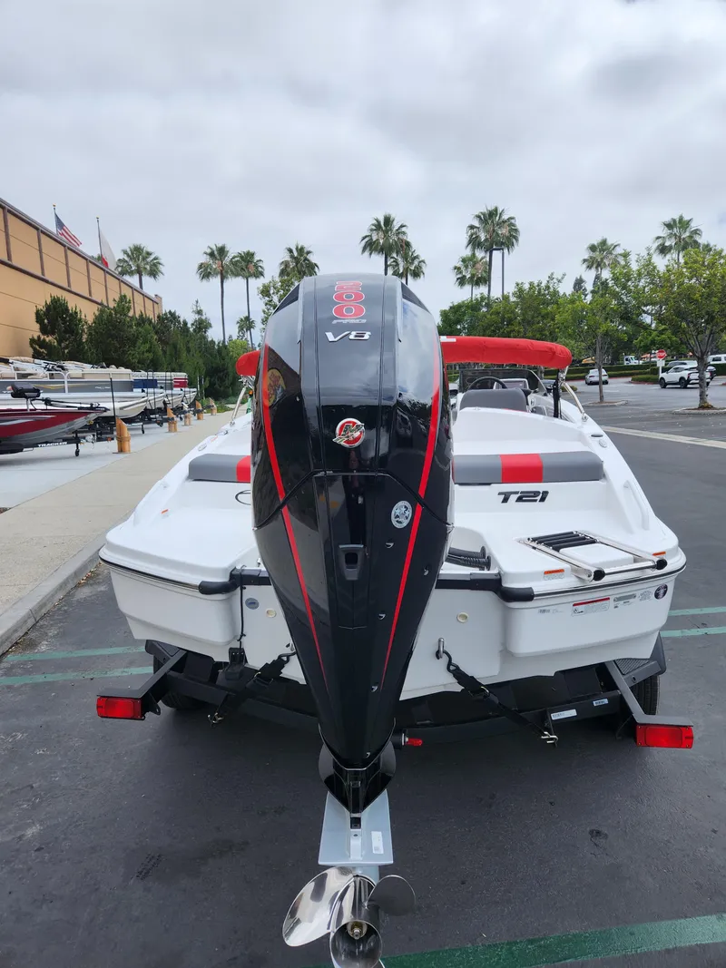 Slide: The Image of 2025 Tahoe T21 boat with powerful outboard motor, parked in a marina lot. - 2