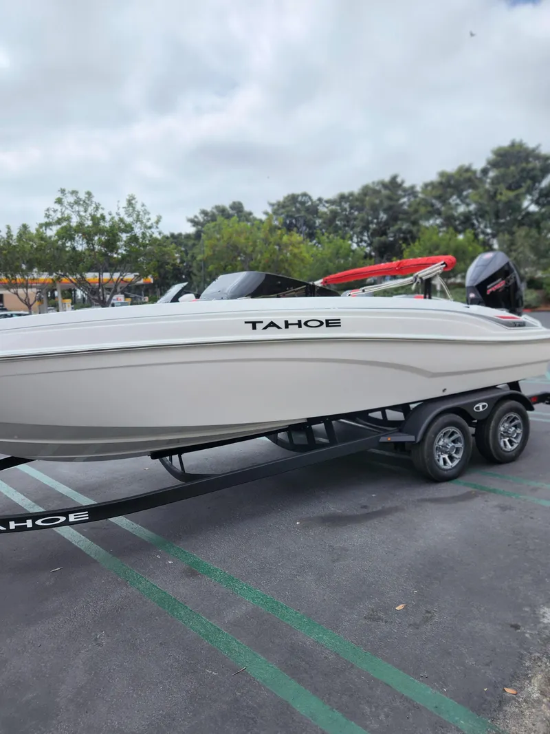 Slide: The Image of 2025 Tahoe T21 boat on trailer in parking lot, overcast sky. - 3