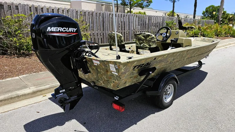 Slide: The Image of 2025 Tracker Grizzly 1754 SC boat with Mercury engine on trailer, parked outdoors. - 2