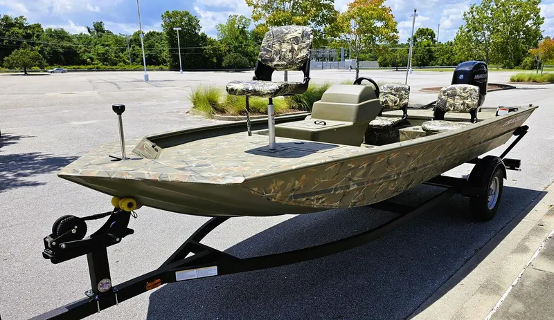 Slide: The Image of 2025 Tracker Grizzly 1754 SC boat with camouflage design on a trailer in a parking lot. - 6