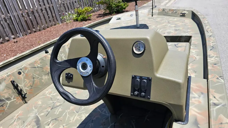 Slide: The Image of 2025 Tracker Grizzly 1754 SC boat interior with steering wheel and control panel. - 8