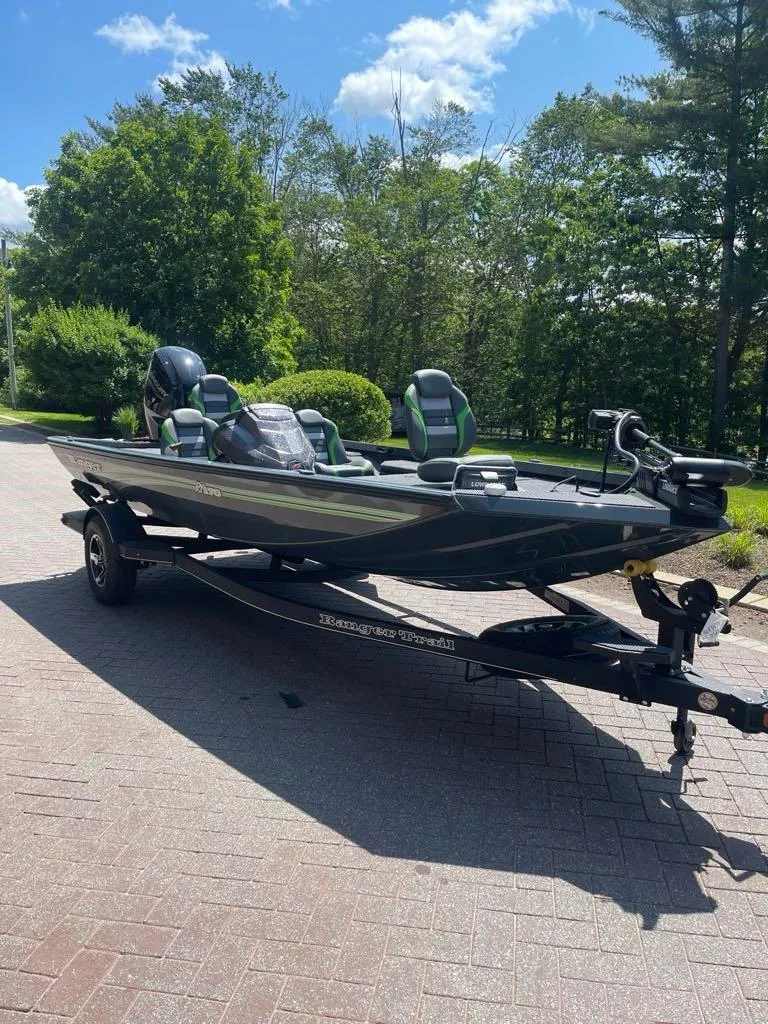 Slide: The Image of 2025 Ranger RT178 boat on trailer, parked outdoors on a sunny day. - 2