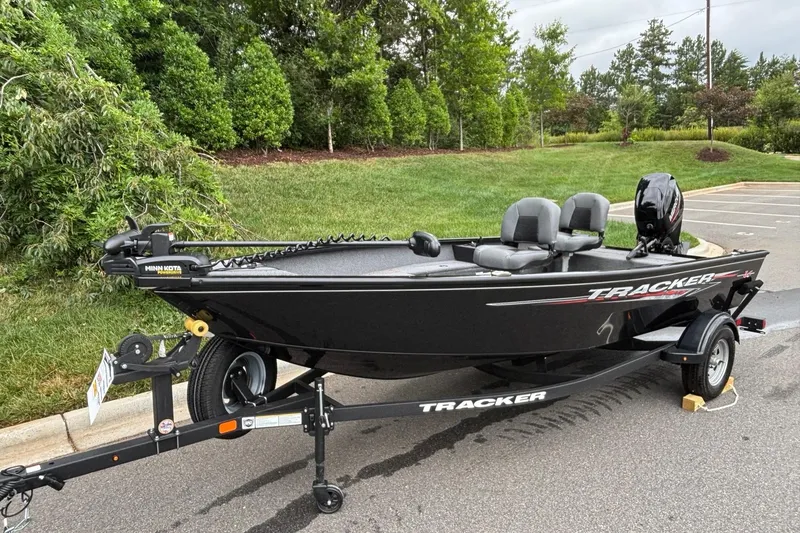 Slide: The Image of 2025 Tracker Super Guide V-16 T boat on trailer, parked outdoors. - 2