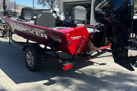 Slide: The Image of 2025 Tracker Pro Team 175 boat, red exterior, on a trailer, with Mercury outboard motor. - 2