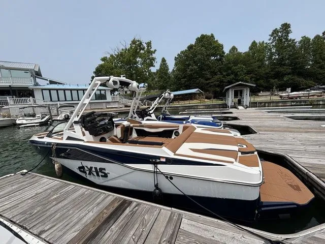 Slide: The Image of 2025 Axis Wake Research T235 boat docked at a marina, featuring sleek design and modern amenities. - 1