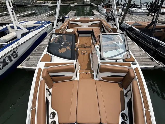Slide: The Image of 2025 Axis Wake Research T235 boat with tan interior, docked at a marina. - 12