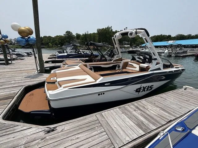 Slide: The Image of 2025 Axis Wake Research T235 boat docked, featuring sleek design and spacious seating. - 2