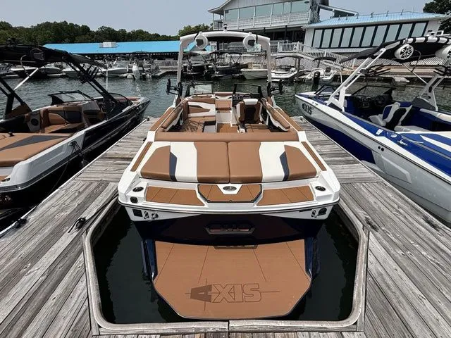 Slide: The Image of 2025 Axis Wake Research T235 boat docked at marina, featuring sleek design and spacious seating. - 3