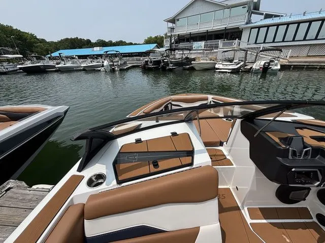 Slide: The Image of 2025 Axis Wake Research T235 boat docked at a marina, featuring sleek interior design. - 7