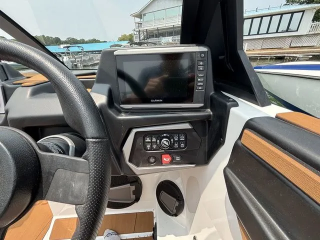 Slide: The Image of 2025 Axis Wake Research T235 boat dashboard with Garmin display and control panel. - 9
