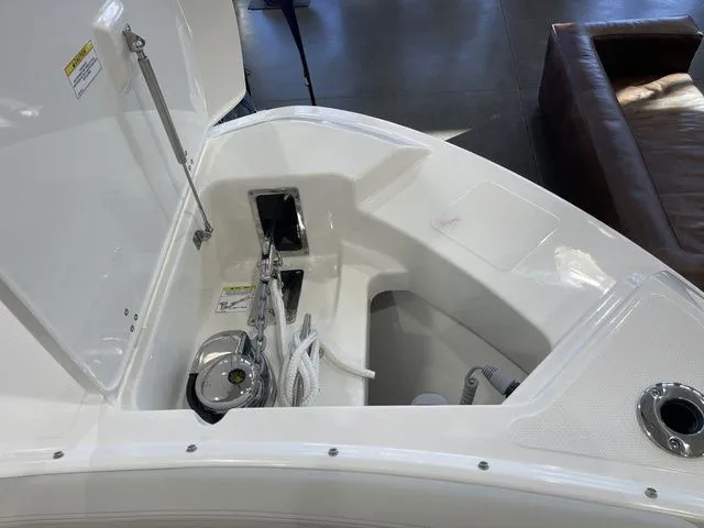 Slide: The Image of 2025 Boston Whaler 240 Vantage anchor compartment with open hatch and visible anchor chain. - 14