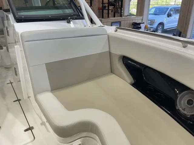 Slide: The Image of 2025 Boston Whaler 240 Vantage boat interior with beige seating and speaker detail. - 17