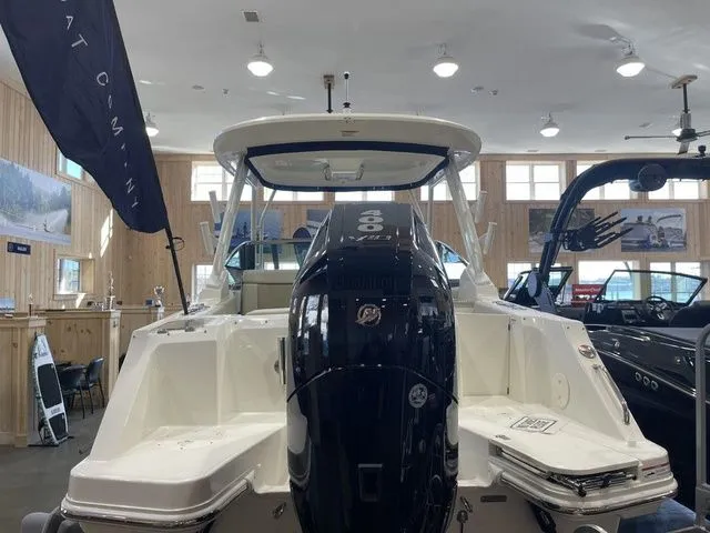 Slide: The Image of 2025 Boston Whaler 240 Vantage boat displayed indoors, showcasing rear view and engine. - 5