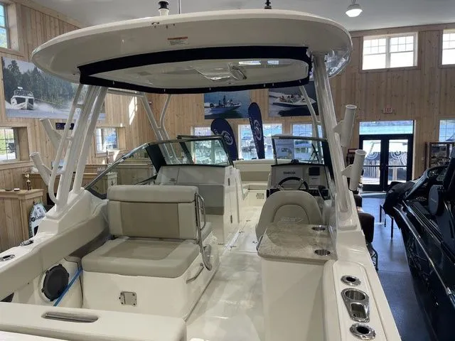 Slide: The Image of 2025 Boston Whaler 240 Vantage boat interior with seating and helm in showroom. - 6