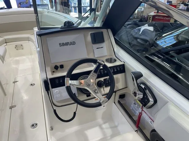 Slide: The Image of 2025 Boston Whaler 240 Vantage boat dashboard with steering wheel and Simrad display. - 8