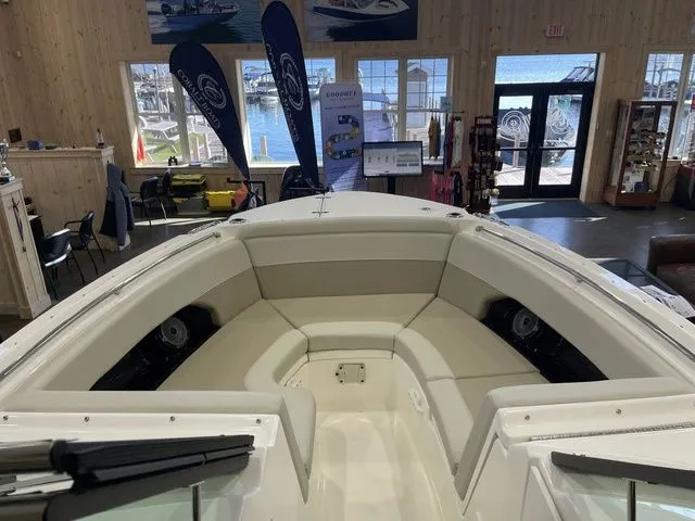 Slide: The Image of 2025 Boston Whaler 240 Vantage boat interior with cushioned seating in a showroom. - 9